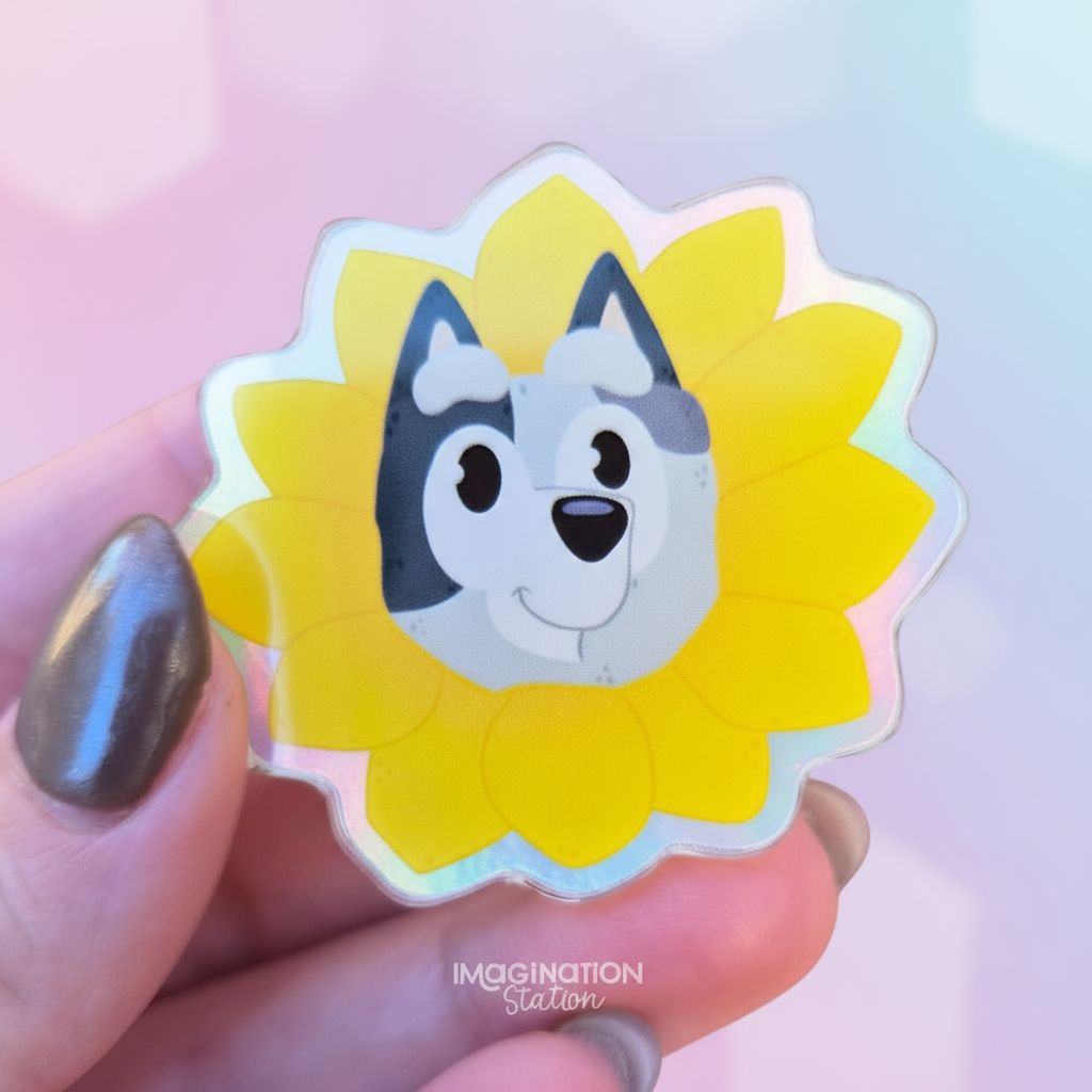 dog face design on a yellow flower-shaped object held by a hand with a blurred autumn background.